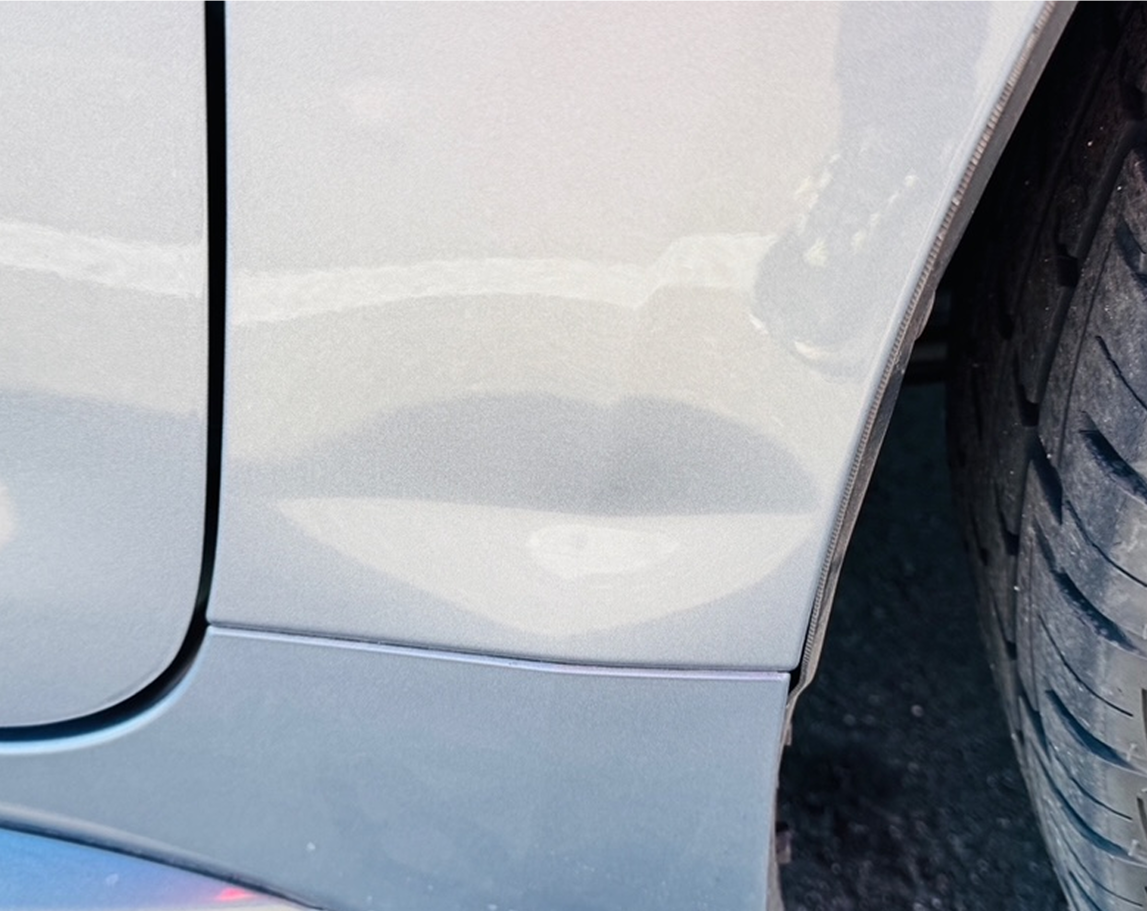 Car dent on silver vehicle door