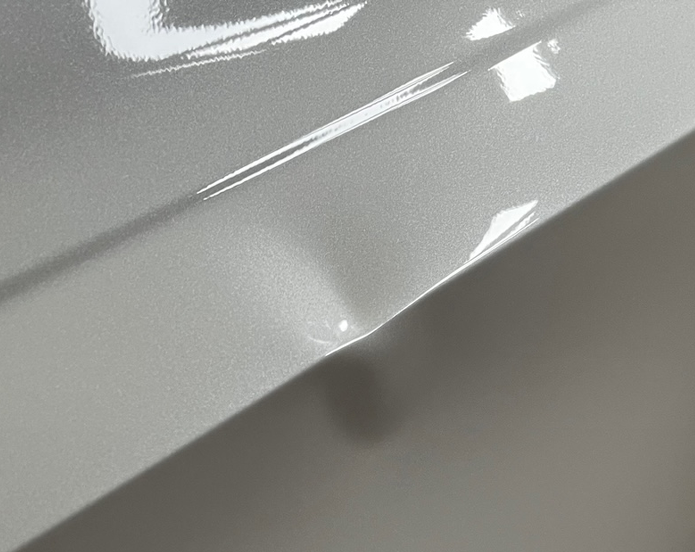 Car surface with small dent and reflection