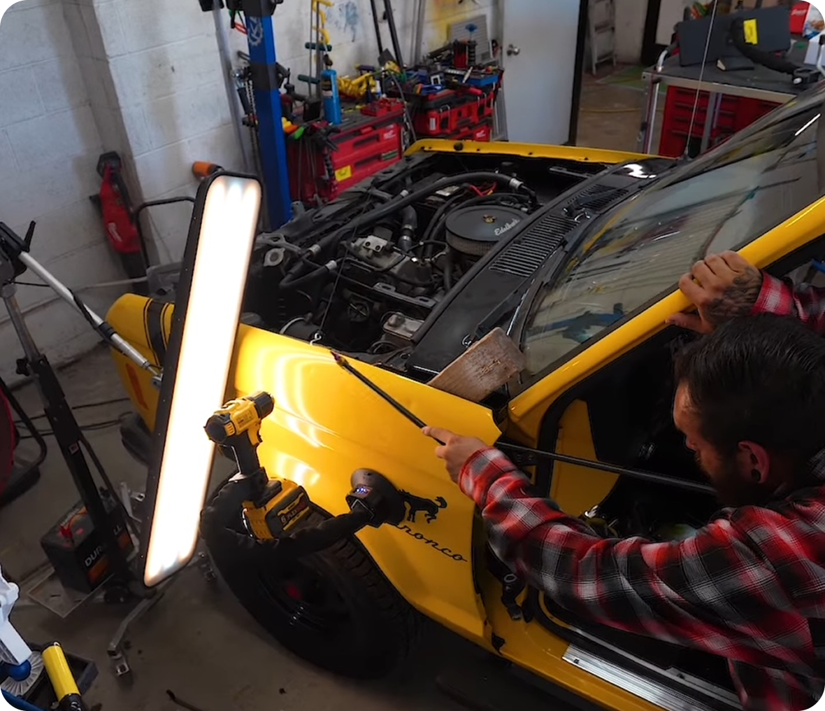 Mechanic working on yellow car engine