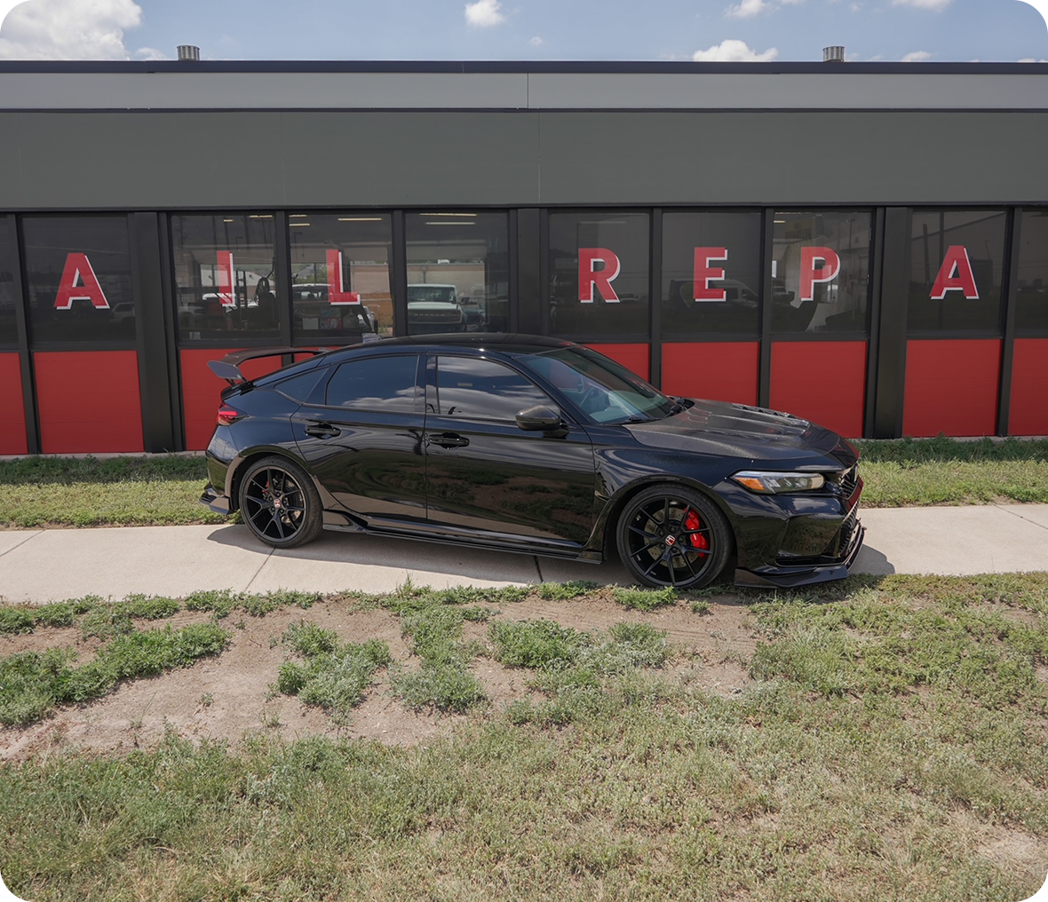 Sporty black car in front of building