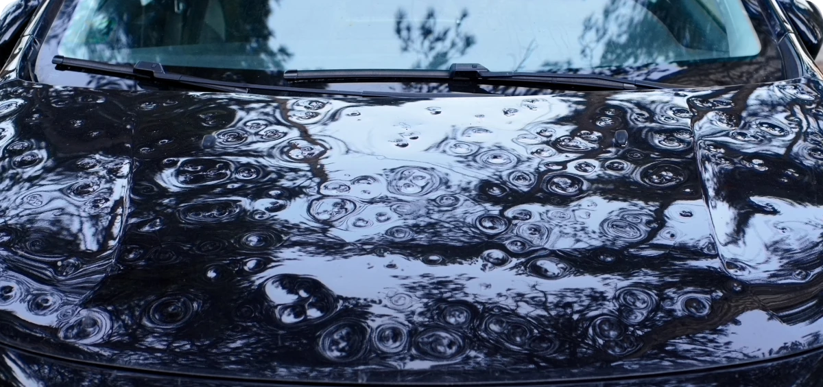 Hail-damaged car hood close-up