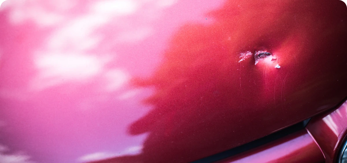 Scratch and dent on red car